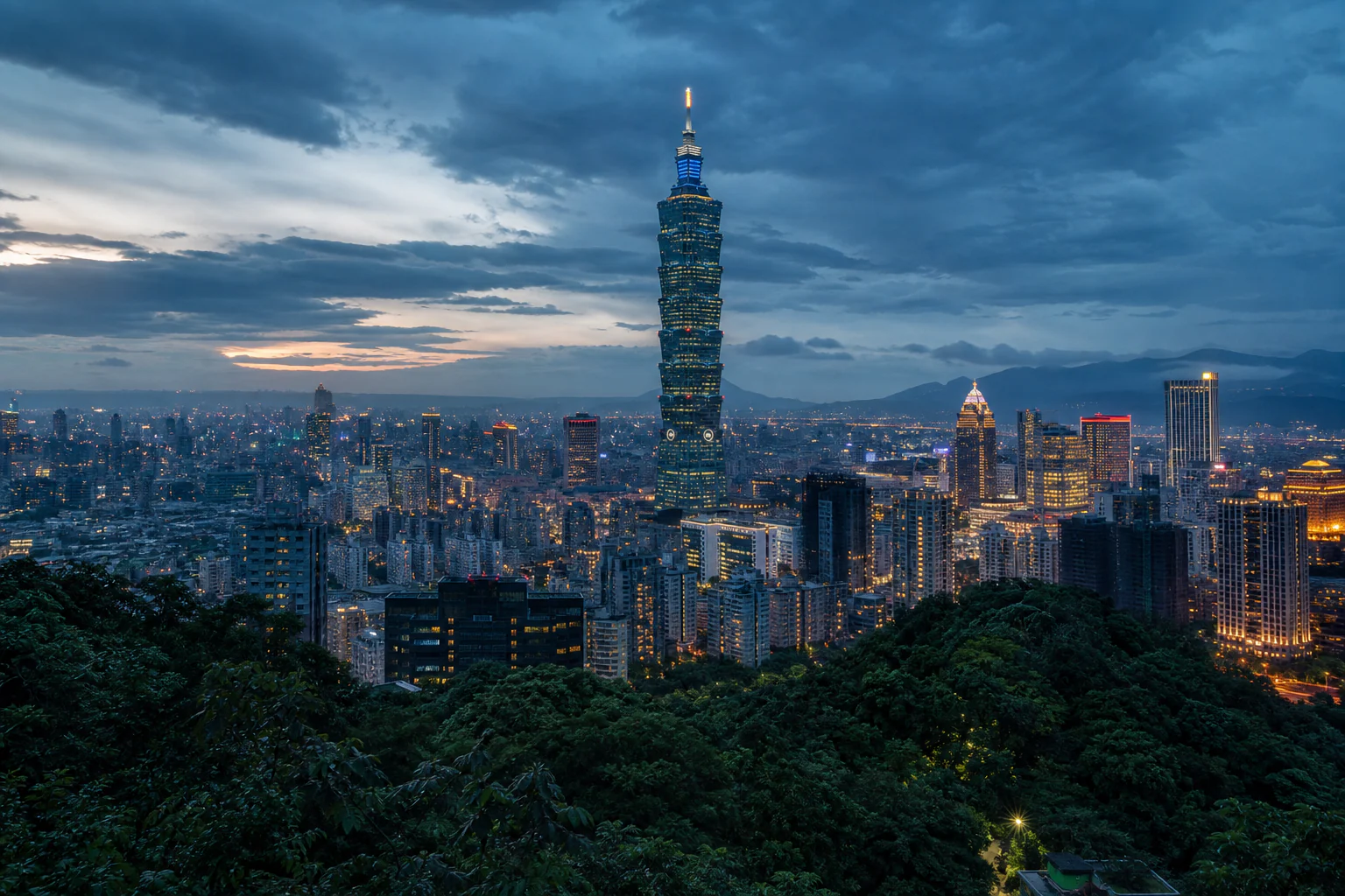 Taipei skyline and Taipei 101 framed by green mountains at dusk